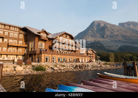 Swiftcurrent Lodge at the Glacier National Park, Montana as seen from the lake side with kayaks / canoes in the foreground Stock Photo