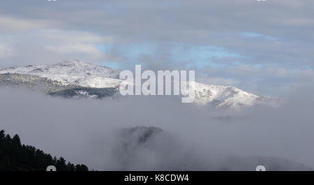 Fog clearing over snow-covered mountains in Colorado near Boulder Stock Photo