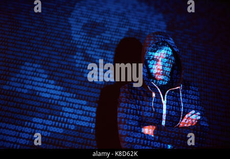 Cyber attack with unrecognizable hooded hacker using virtual reality, digital glitch effect Stock Photo