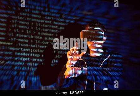 Cyber attack with unrecognizable hooded hacker using virtual reality, digital glitch effect Stock Photo