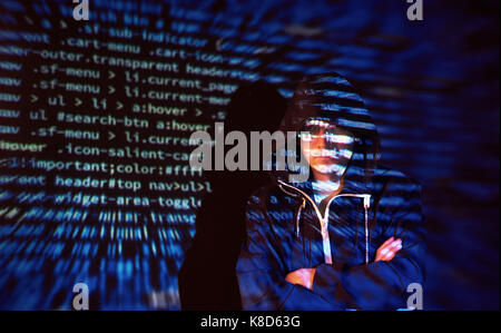 Cyber attack with unrecognizable hooded hacker using virtual reality, digital glitch effect Stock Photo