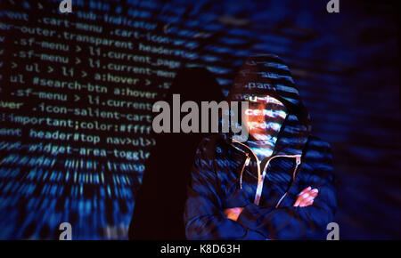 Cyber attack with unrecognizable hooded hacker using virtual reality, digital glitch effect Stock Photo