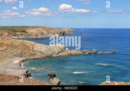 Coastal view on Balearic island of Minorca in the Mediterranean sea with sailing boats in the distance Stock Photo