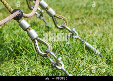 End of swinging rope hang on metal construction in a park. Rough rope end  in metal circles and safety snap hook Stock Photo - Alamy