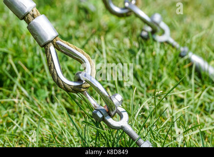 End of swinging rope hang on metal construction in a park. Rough rope end  in metal circles and safety snap hook Stock Photo - Alamy