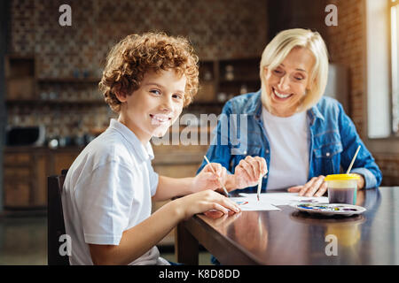 Excited curly haired child enjoying spending time with granny Stock Photo