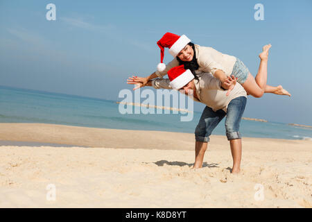 Christmas couple having fun on a beach Stock Photo