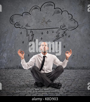 Businessman practice yoga under a rainy cloud Stock Photo