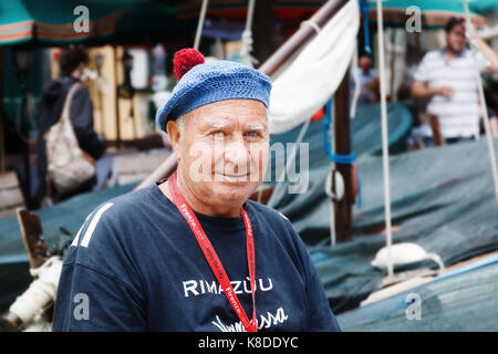 Vernazza (SP), Italy - September 15, 2017: Portrait of an old fisherman, against the background of boats parked at the small harbor. Stock Photo