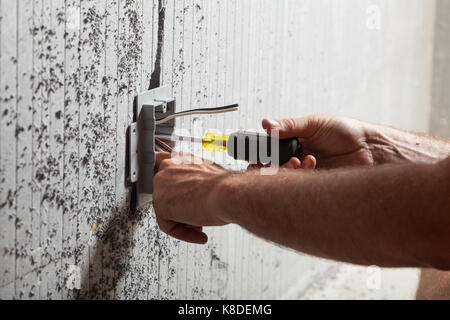 An electrician securing an electrical utility box using a screwdriver into  insulated concrete form in Ontario, Canada Stock Photo - Alamy