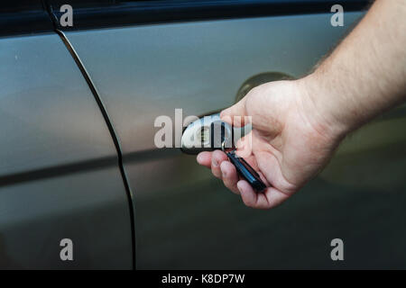 man's hand opens the car door with a key. Stock Photo