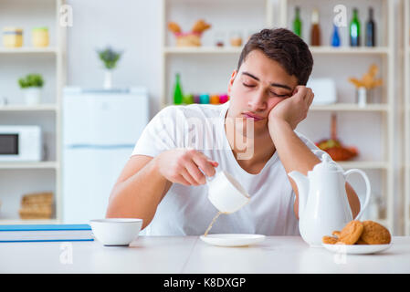 Man falling asleep during his breakfast after overtime work Stock Photo