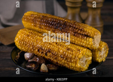 Grilled corn cobs on wooden table Stock Photo