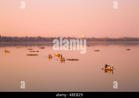 Boats on the Taungthaman Lake at sunset in Amarapura, Mandalay, Myanmar Stock Photo
