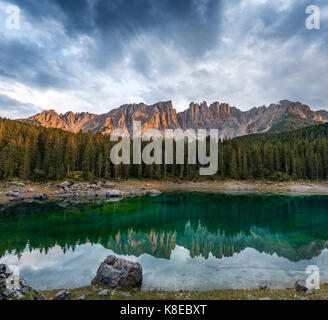 Sunset, dramatic clouds, Latemar group reflected in the Karersee, Diamantidturm, mountain peaks, Eastern Latemarspitze Stock Photo