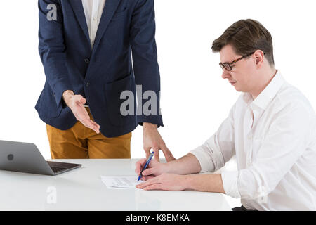 Two young businessmen signing contracts at office desk Stock Photo