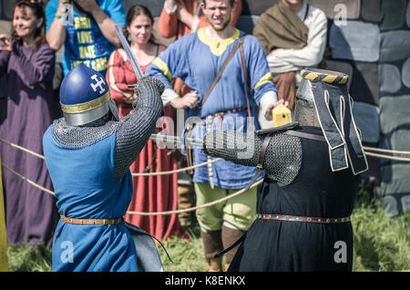 MOSCOW,RUSSIA-June 06,2016: Martial duel of two medieval teutonic warriors. Knights in full armour fight with swords on arena. Stock Photo