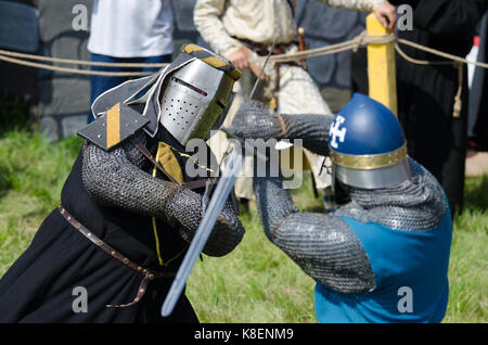 MOSCOW,RUSSIA-June 06,2016: Martial duel of two medieval teutonic warriors. Knights in full armour fight with swords on arena. Stock Photo