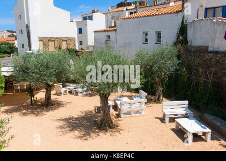 Courtyard with seating and olive trees, in the small fishing town of cadaques, typical Mediterranean village on the Costa Brava of Catalonia, Spain Stock Photo