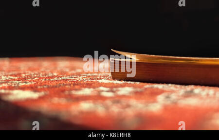 Book is illuminated by sun on red carpet Stock Photo