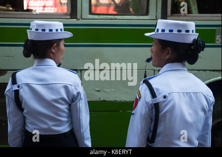 26.01.2017, Yangon, Yangon Region, Republic of the Union of Myanmar, Asia - Two female traffic police officers stand at the side of a road in Yangon.