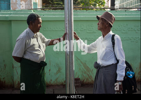 27.01.2017, Yangon, Yangon Region, Republic of the Union of Myanmar, Asia - Two men are seen standing at a bus stop in central Yangon.