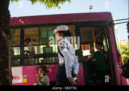 27.01.2017, Yangon, Yangon Region, Republic of the Union of Myanmar, Asia - A female traffic police officer stands at a bus stop in central Yangon.