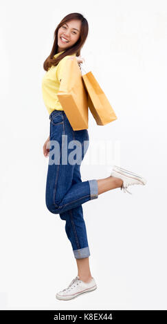 asian thai lady hold paper shopping bag and happy smile with casual shirt and jeans on white background Stock Photo