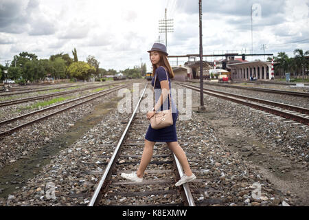 asian thai lady walking on railway on journy concept in summer Stock Photo
