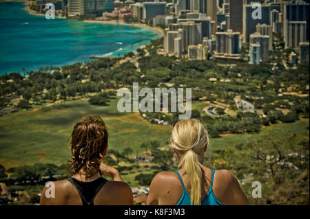 Two female tourists enjoying the view of Waikiki tourist area of Honolulu from Diamond Head mountain Stock Photo