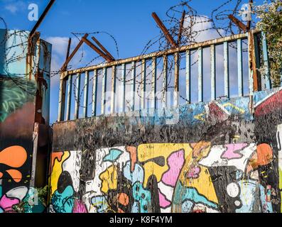 A rusty, urban metal security gate with graffiti. Stock Photo