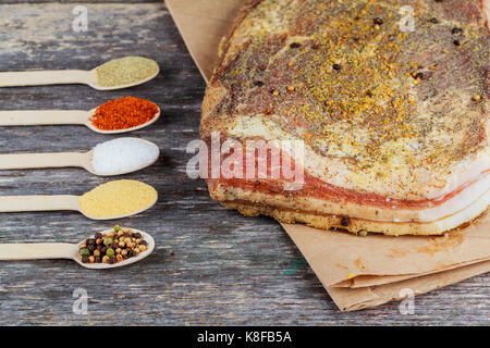 Piece and slices of salted bacon on wooden table. Studio Photo spices with salty bacon Stock Photo