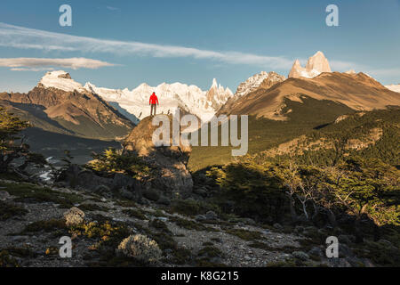 Male hiker looking out Cerro Torre and Fitz Roy mountain range in Los Glaciares National Park, Patagonia, Argentina Stock Photo