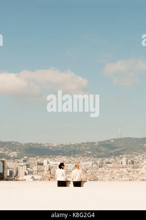 Rear view of female tourists looking out over cityscape, Barcelona, Spain Stock Photo