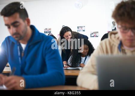 Teacher in classroom helping students study Stock Photo