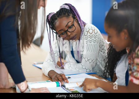 Teacher in classroom helping students study Stock Photo