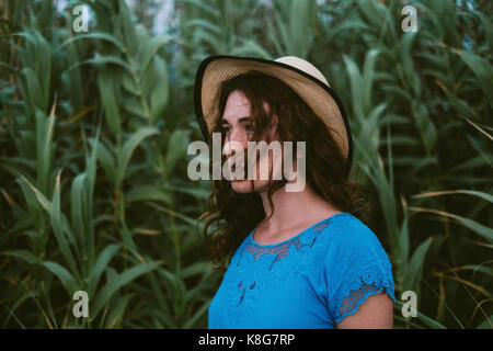 Thoughtful woman wearing hat standing on field Stock Photo