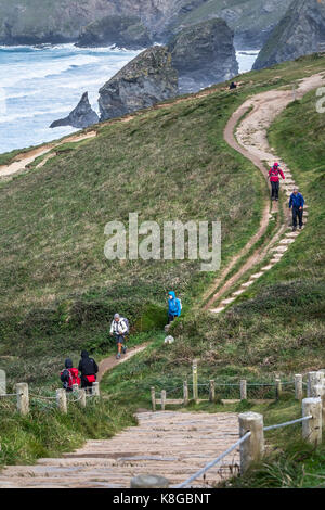 Bedruthan Steps - Walkers climbing up and down steep steps on the South West Coast Path at Bedruthan Steps on the North Cornwall coast. Stock Photo