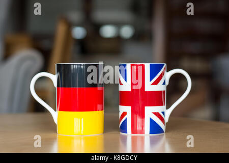 German and Great Britain flag on two mugs close up with blurry background Stock Photo