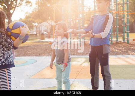 Children playing basketball in playground Stock Photo