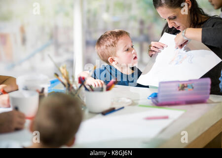 Teacher teaching boy to draw Stock Photo