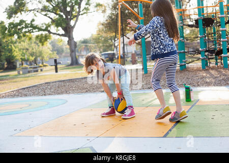 Children playing basketball in playground Stock Photo