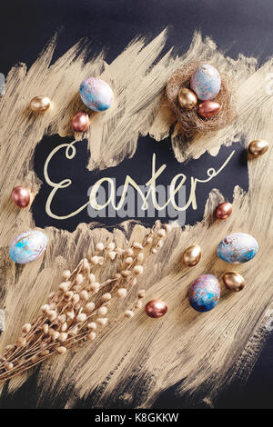 Overhead view of dyed and gold painted easter eggs with handwritten easter Stock Photo