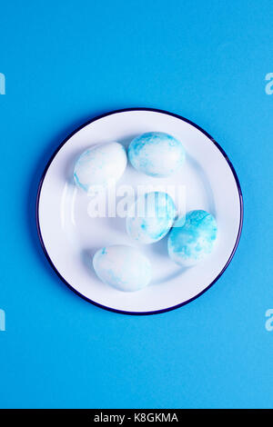 Overhead view of blue dyed easter eggs on blue background Stock Photo