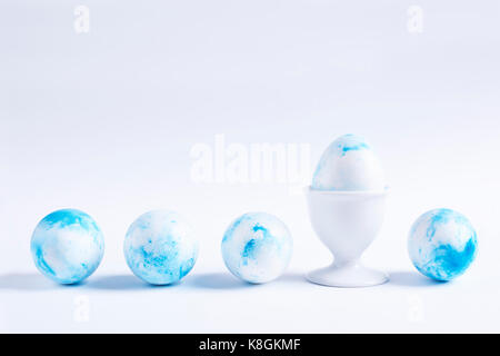 Row of blue dyed easter eggs on white background Stock Photo