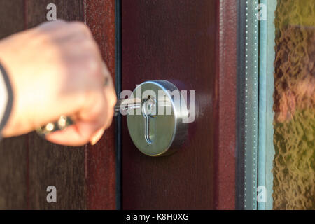 Open the wooden door with the key close up Stock Photo