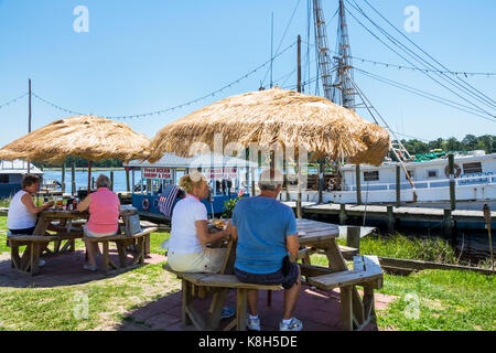 North Carolina,NC,Calabash,fishing town,seafood,regional cuisine,dining,al fresco sidewalk outside tables,straw umbrella,fishing boat,dock,Captain Nan Stock Photo