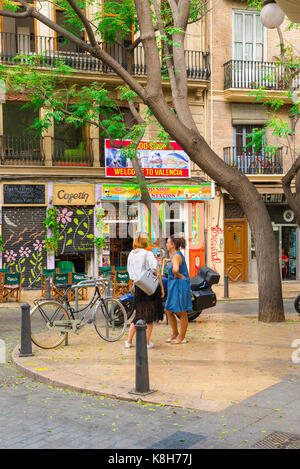 Women talking street, view of two women chatting on a street corner in the Plaza Tossal in the old town Barrio del Carmen area of Valencia, Spain. Stock Photo