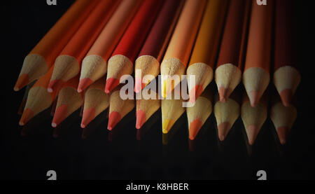 Orange Pencils with Reflection in Mirror with black Background Stock Photo