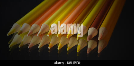 Yellow Colored Pencils with Reflection on Mirror on a Black Background Stock Photo